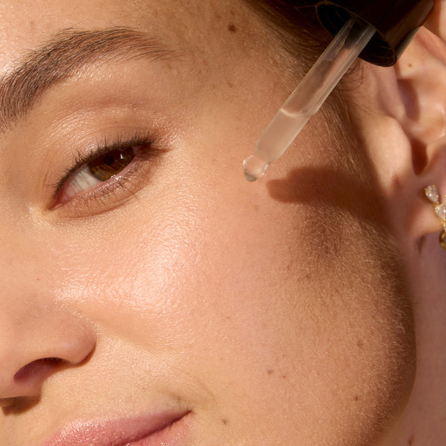 AI application of Organax Ltd ACURE AI Peptide Serum in a 30ml skincare bottle, showing the serum being applied to skin.