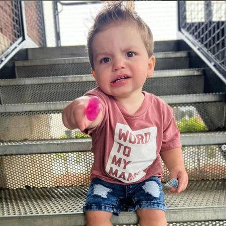 Child sitting on steps holding Zollipops® strawberry flavor sugar-free lollipops from Organax Ltd.