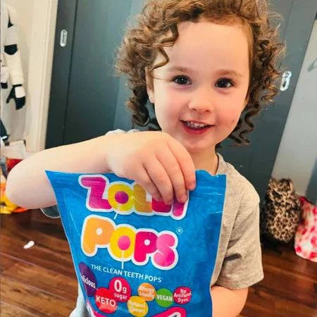 Child with curly hair holding assorted fruit-flavored Zollipops sugar-free lollipops in a tub by Organax Ltd.