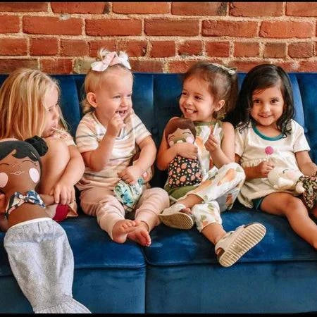 Four children sitting on a couch enjoying Zollipops Original Clean Teeth Sugar-Free Candy in a large jar.