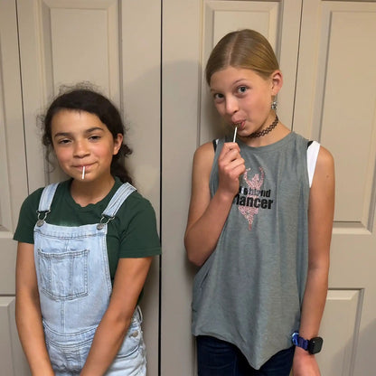 Girls holding Zollipops Elderberry sugar-free lollipops with vitamin C and zinc, in a 227g package, from Organax Ltd.