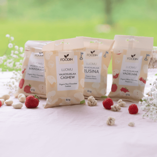 Organic white chocolate cashew snack by Organax Ltd in a 60g package, shown as a close-up of the white chocolate and cashews.