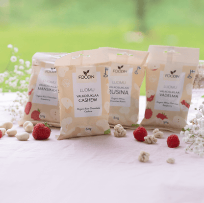 Organic white chocolate cashew snack by Organax Ltd in a 60g package, shown as a close-up of the white chocolate and cashews.