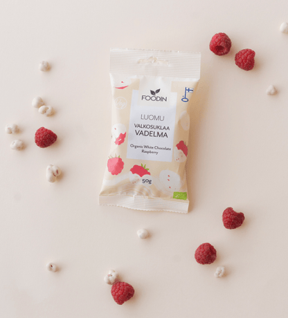 Organic white chocolate with raspberry from FoodIn by Organax Ltd, shown in 50g package with white chocolate and raspberry pieces.