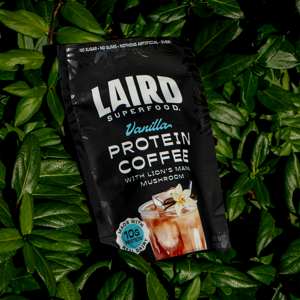 Laird Vanilla Protein Coffee with Lion's Mane by Organax Ltd in a 150g package, showing a bag of flavored protein coffee powder.