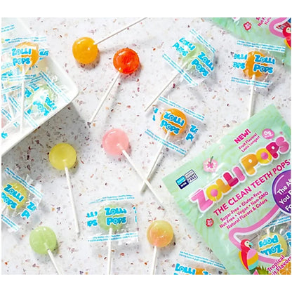 Assorted tropical fruit Zollipops zero sugar lollipops in colorful packaging, displayed in a lifestyle setting.