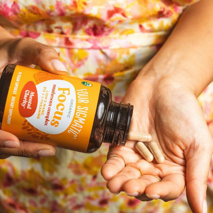 Organic Mushroom Capsules by Organax Ltd featuring Lion's Mane, B12, and L-Theanine in a clear bottle with capsules.
