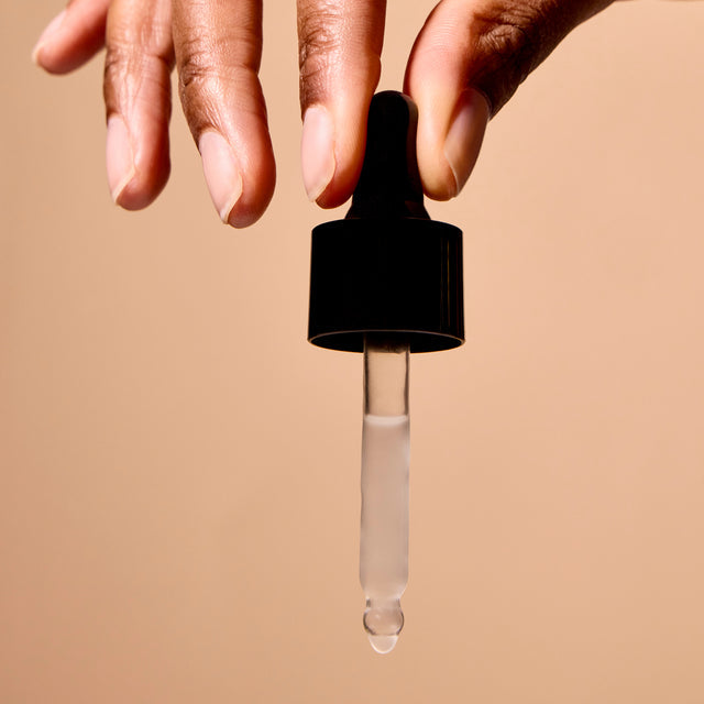 Brightening glow serum dropper from ACURE Skin Care in a 30ml bottle, featuring a clear glass dropper and a vibrant glow in the background.
